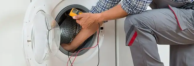 Dryer repair technician inspecting and repairing a clothes dryer in Sioux Falls, SD