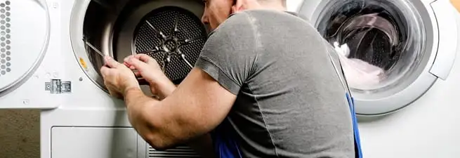 Dryer repair technician fixing a clothes dryer drum in Sioux Falls, SD