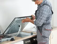 Appliance repair technician installing a built-in cooktop in Sioux Falls, SD