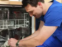 Dishwasher repair technician inspecting and servicing an open dishwasher in Sioux Falls, SD