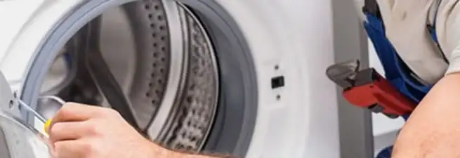 Appliance technician repairing a clothes dryer drum and internal parts in Sioux Falls, SD