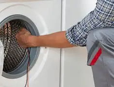 Dryer repair technician diagnosing and servicing a clothes dryer in Sioux Falls, SD