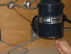 Garbage disposal repair technician tightening the mounting ring under a sink in Sioux Falls, SD