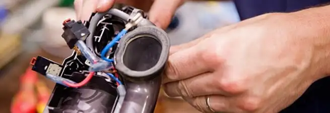 Vacuum repair technician reconnecting wiring and components in Sioux Falls, SD