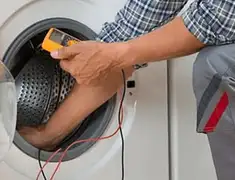 Washing machine repair technician testing a front-load washer with diagnostic tools in Sioux Falls, SD