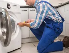Washing machine repair technician servicing a front-load washer in Sioux Falls, SD