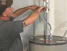 Water heater repair technician tightening supply line connections in Sioux Falls, SD